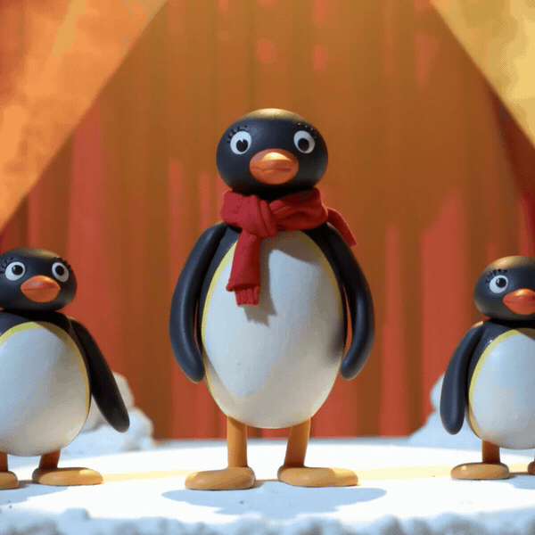Claymation style dancing penguin wearing a red scarf on a snowy stage under warm spotlights, playful stop-motion look