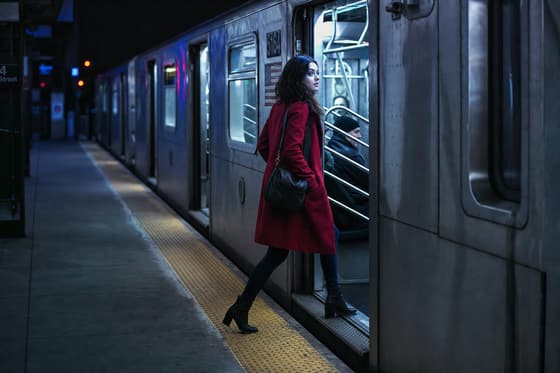 Still: the train pulling in as the woman in the red coat prepares to board.