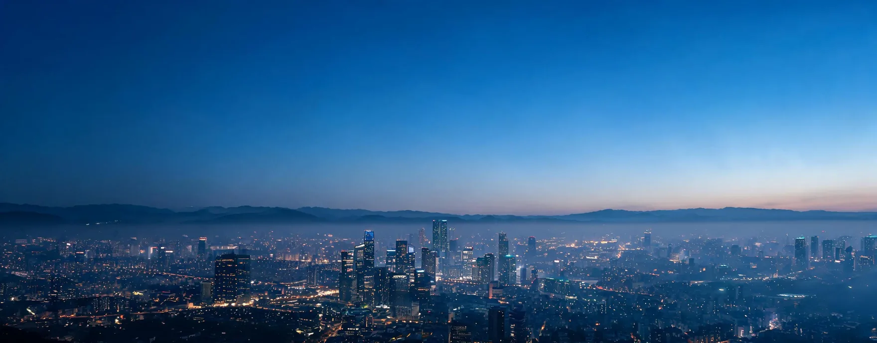 Wide city skyline at blue hour, an image extended to a panoramic crop